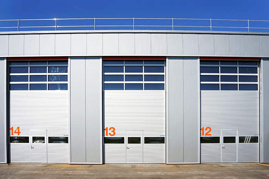 Porte sectionnelle avec porte piéton et fenêtre